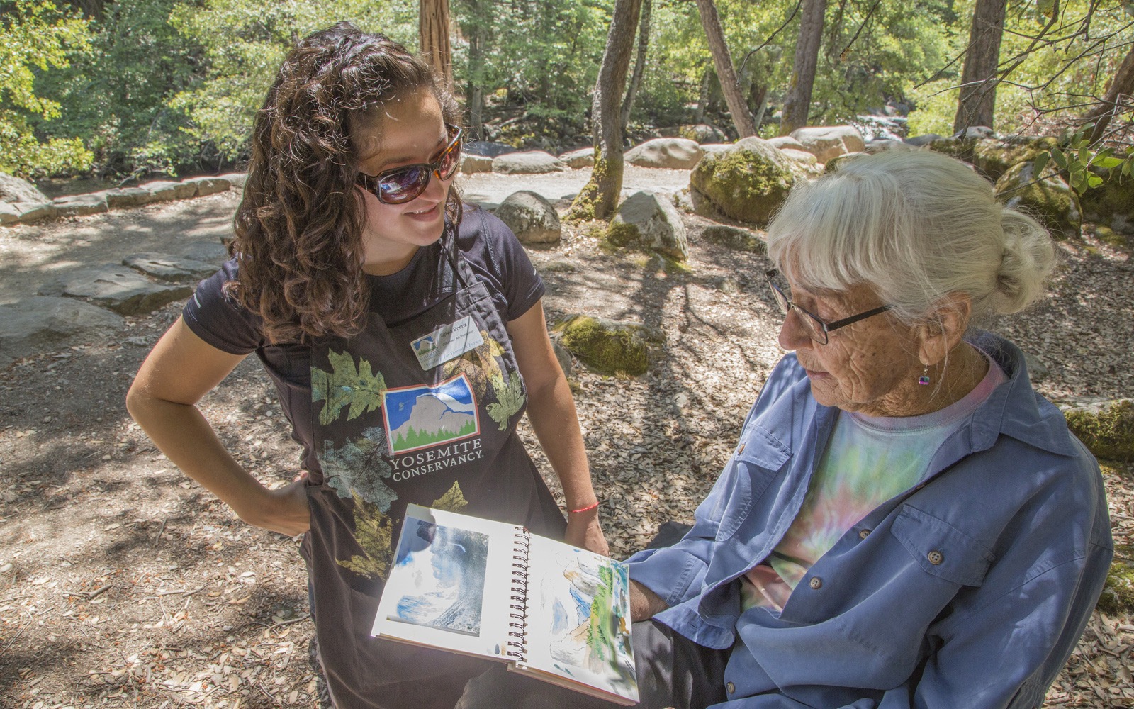 Sylvia Eneriz, one of our 2019 volunteer art instructors, works with a participant during a summer class near Happy Isles.