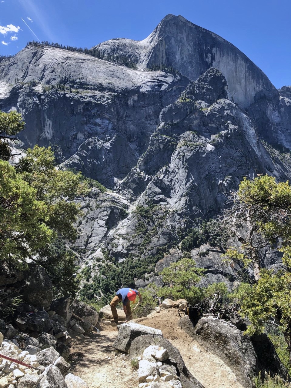 Photo of a worker on the Snow Creek Trail in Yosemite, with Half Dome in the background.