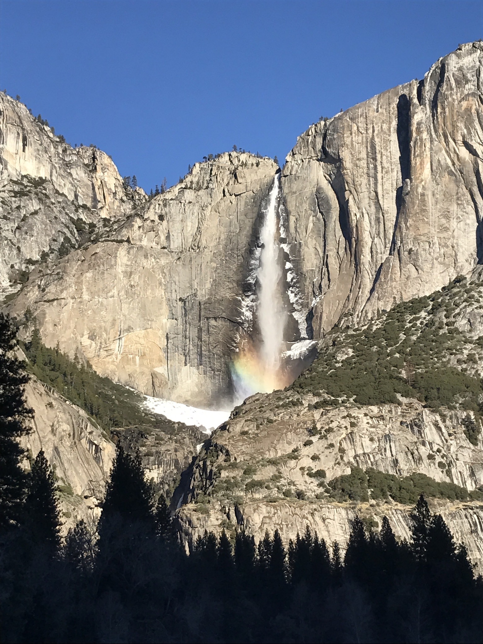 A beauty shot of Yosemite Falls, with a rainbow visible in the mist and snow piled up at the base of the upper fall. Photo: Melissa King.