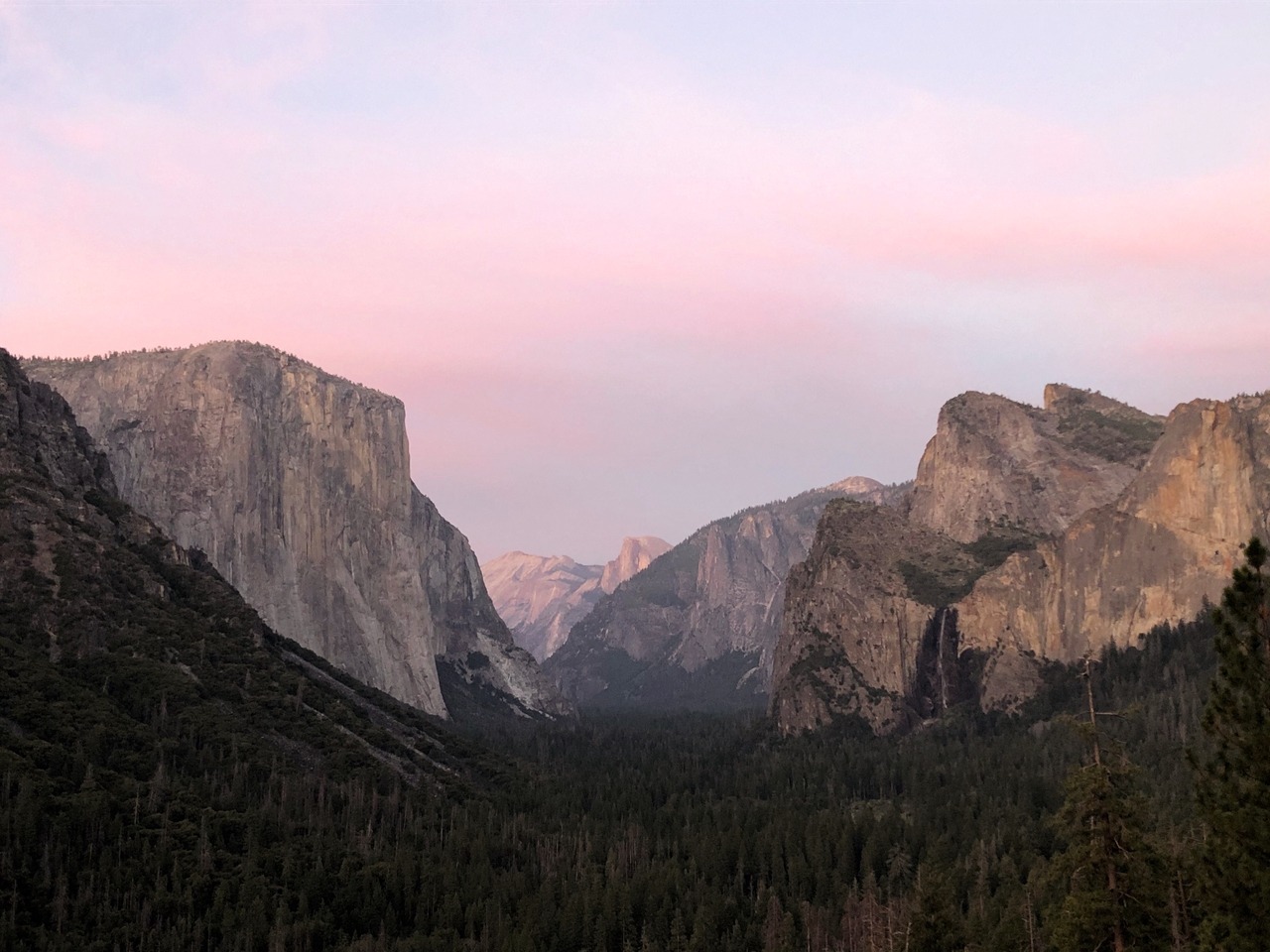 Pink sky at sunset at Tunnel View vista. El Capitan on the left and Bridalveil Fall on the right.