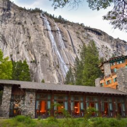 Heavy snow in the High Sierra melting over Yosemite Valley walls at the Royal Arches Cascade. In the foreground there is the Ahwahnee Hotel. 