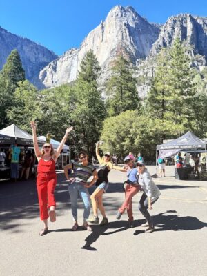 Facelift Volunteers showing their excitement at the Facelift Event in Yosemite Valley. We see Yosemite Falls in the background. 