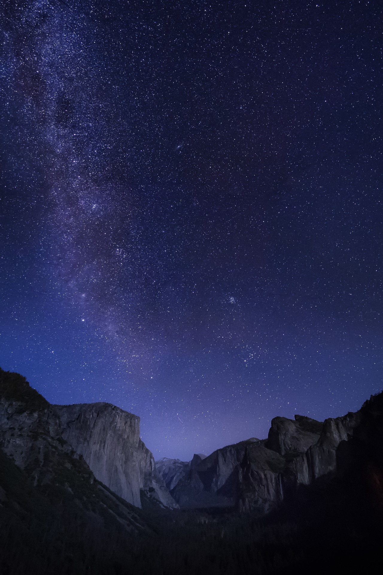 A night scene at Tunnel View, with the Milky Way and stars visible over El Capitan, Cathedral Rocks and Half Dome.