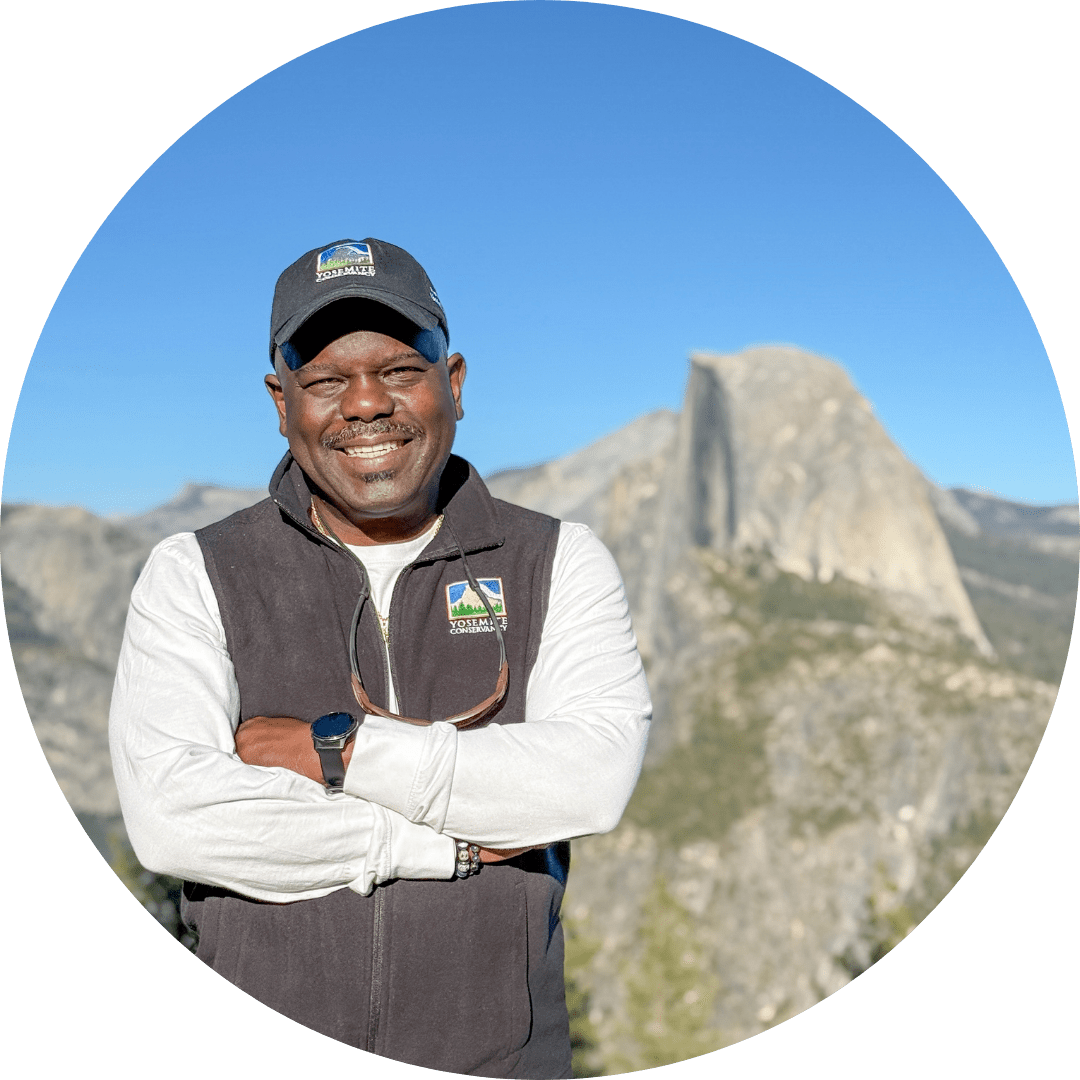 Cassius M. Cash stands at Glacier Point with Half Dome in the background.