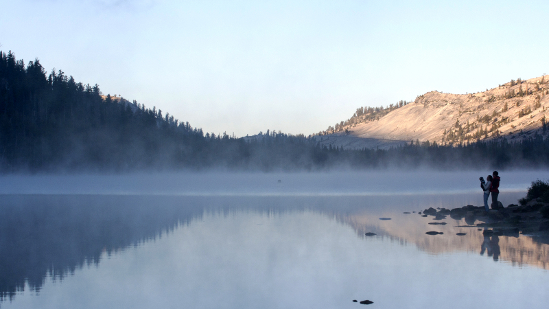 A family enjoys a misty summer morning on the shores of Tenaya Lake. Photo: Yosemite Conservancy/Keith Walklet