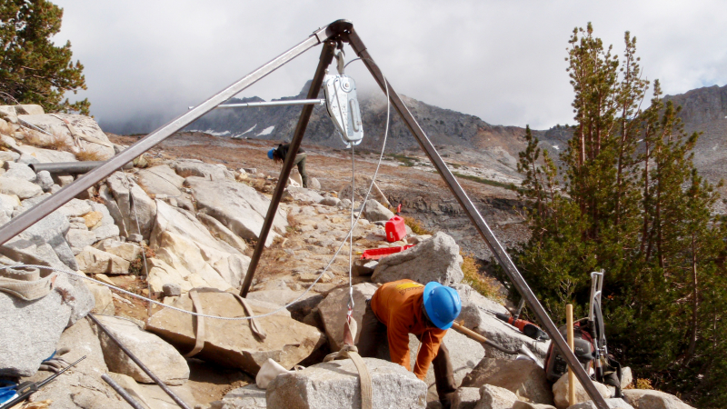 Crew members use special equipment to move heavy rocks on the Red Peak Pass trail. Photo: NPS, 2010