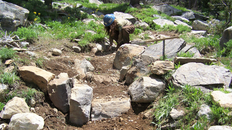 A CCC crew member works on repairing steps near Summit Pass. Photo: NPS, 2017