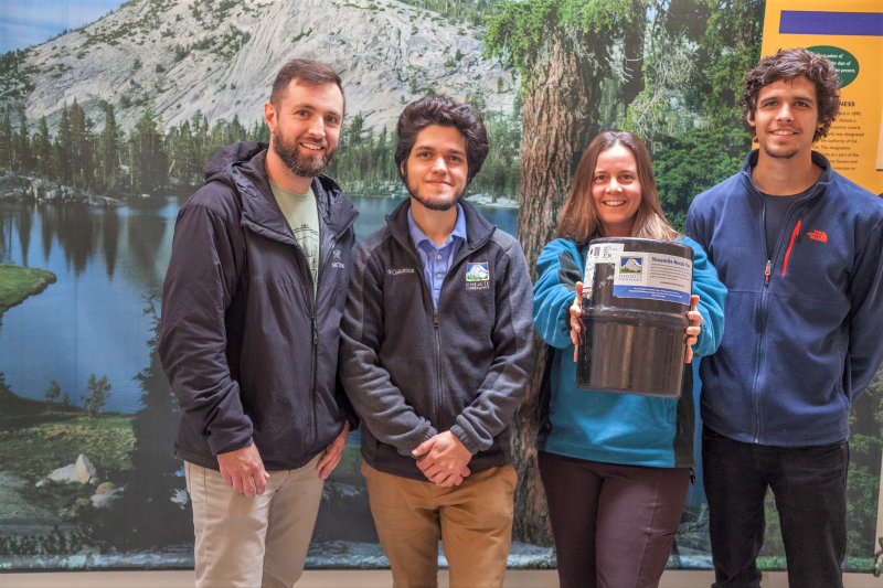 The Wilderness Team shows off a bear-proof food canister. Stop by to rent one for your next backpacking trip in the park — it will help keep your food, and the bears, safe! Photo: © Yosemite Conservancy/Keith Walklet