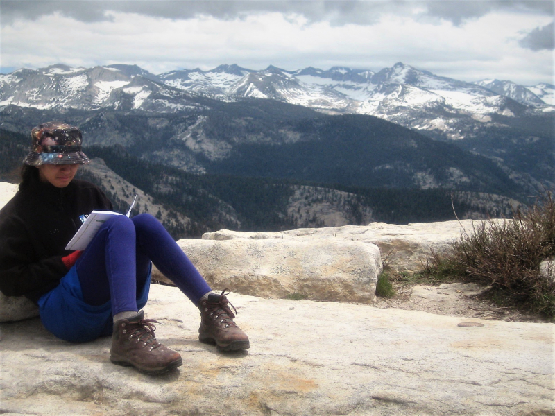 The clouds aren't the only things that rest at Clouds Rest! A WildLink student pauses at the summit to work on a writing activity, a key element of the program's curriculum.